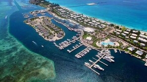 An aerial view of a coastal resort with multiple buildings, a marina, and clear blue waters. - Luxury Ocean Villa 3 Bed / 3 Bath in Bimini Bay (Bimini)