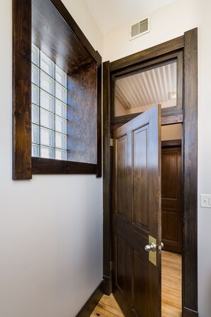 A wooden door with a glass panel and a metal handle.