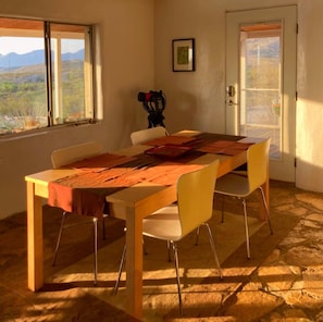 Un comedor con una mesa, sillas y vistas al exterior.