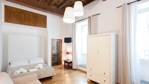 A bedroom with a bed, a wardrobe, a bedside table with a lamp, and a window with curtains. - SPECIAL OFFER - in the Heart of ancient Rome (Roma)