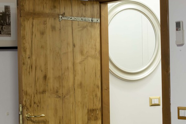 Une porte en bois avec une poignée en laiton et un loquet métallique.