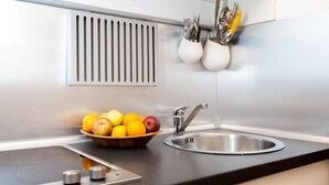 A modern kitchen with a stainless steel sink, a bowl of fruit, and a vent above the sink. - SPECIAL OFFER - in the Heart of ancient Rome (Roma)