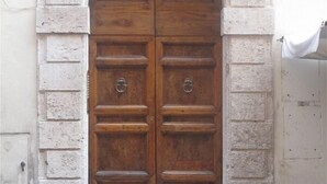 A large wooden double door with a stone archway, set in a building with a plain facade. - SPECIAL OFFER - in the Heart of ancient Rome (Roma)