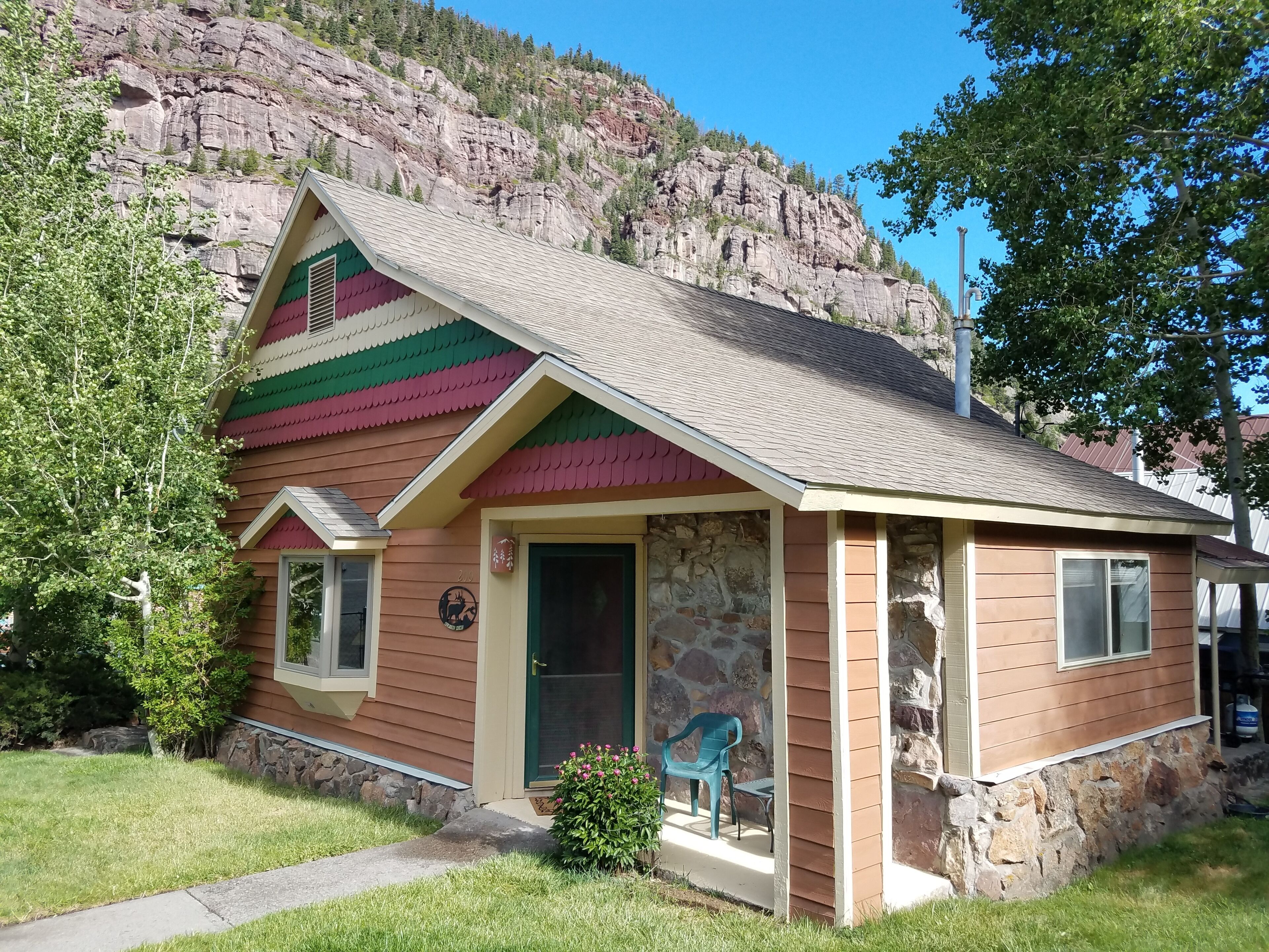 A small, single-story building with a stone facade and a colorful roof.