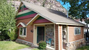 Un edifici petit d'una sola planta amb façana de pedra i teulada colorida.