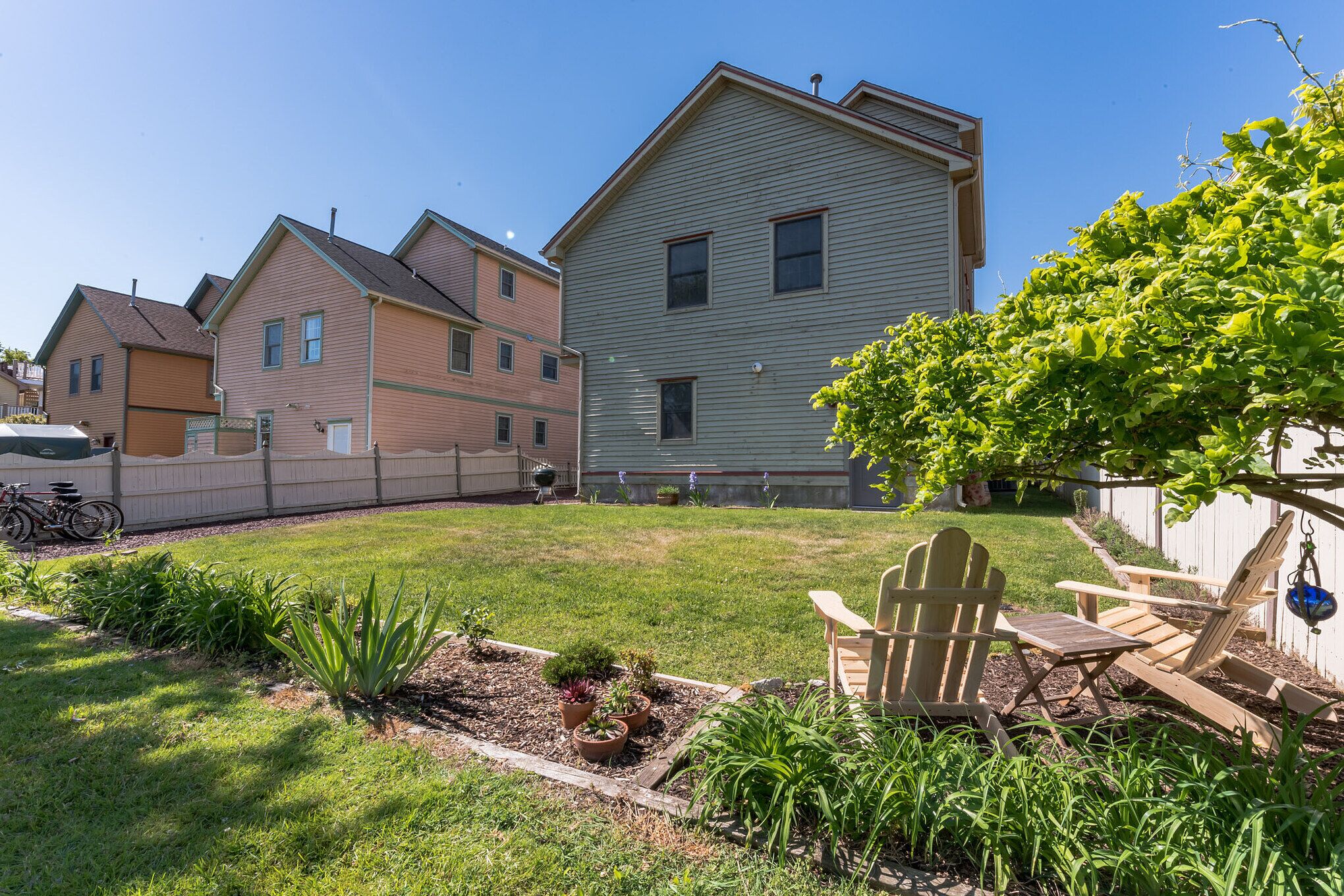 Un quartier résidentiel avec des maisons, une pelouse et une chaise en bois.