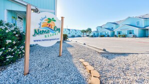 A sign for Nemo Cay Resort with a clear view of the resort's buildings in the background. - Family-Friendly Townhome | Heated Pool, Patio & Beach Nearby (Corpus Christi)