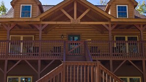 A two-story log cabin with a balcony and a staircase. - Beautiful Mountain Top Retreat Long Range Views, Hot Tub,Ping Pong,Horseshoe pit (Maggie Valley)