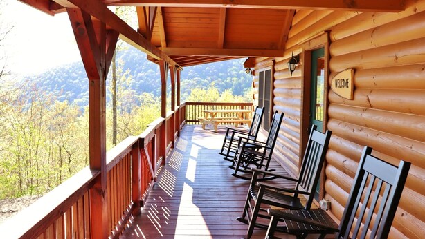 A wooden cabin with a porch, wooden benches, and a "WELCOME" sign. - Beautiful Mountain Top Retreat Long Range Views, Hot Tub,Ping Pong,Horseshoe pit (Maggie Valley)