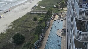 Um hotel com área de piscina, praia e vista para o oceano.