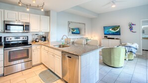 A modern kitchen with stainless steel appliances, a granite countertop, and a built-in dishwasher.