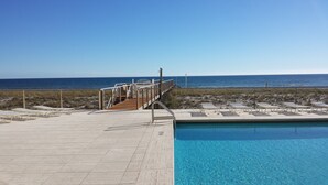 A pool area with a view of the ocean, a wooden deck, and lounge chairs. - Spacious Belle Mer 3BR -- 2 Gulf Front Masters -- All with Private Baths (Navarre Beach)