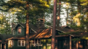 A rustic cabin with a stone chimney, a porch, and a sign reading "Office" and "Gift Shop".