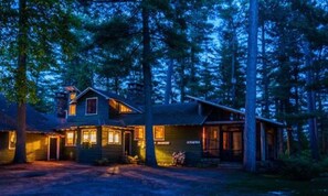 Une cabane dotée d’un porche à l’avant, d’une porte bien visible et d’une petite dépendance attenante.