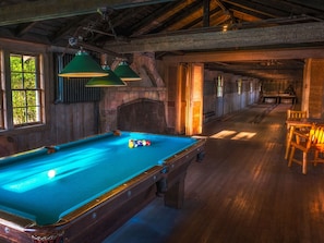 Une table de billard avec des billes, des murs en bois et un plafond en bois.