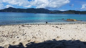 A beach with clear blue water, a rocky shoreline, and distant mountains. - Gorgeous View, Beach Access, Swimming Pool, Kayak, Quiet Privacy - the East End (St. John)