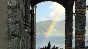A stone archway leading to a view of the sea with a rainbow. - Gorgeous View, Beach Access, Swimming Pool, Kayak, Quiet Privacy - the East End (St. John)