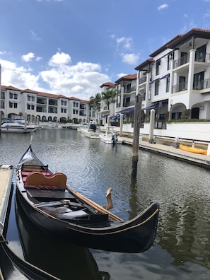 Un canal con góndolas y una hilera de edificios con balcones y ventanas arqueadas.