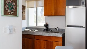 Une cuisine moderne avec des meubles en bois, un réfrigérateur en acier inoxydable et un plan de travail blanc.