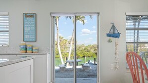 A kitchen with a view of a lake, a wooden chair, and a sign with beach rules. - One Bedroom remodeled stand-alone Unit - steps from our private beach. (Nokomis)