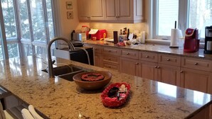 A kitchen with granite countertops, wooden cabinets, and pendant lighting. - Lakefront Spectacle In Beaver Valley / Lake Eugenia (Flesherton)
