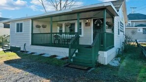 A single-story mobile home with a covered porch and a small front yard. - Year-Round Hampton Beach Retreat-3BR Beach Ranch w/Central A/C, Heat & Parking (Hampton)
