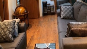 A living room with a wooden staircase, a sofa, and a coffee table.