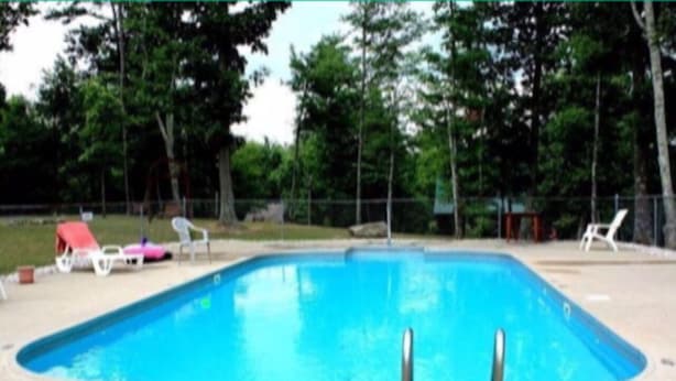 A rectangular swimming pool with a tiled deck.