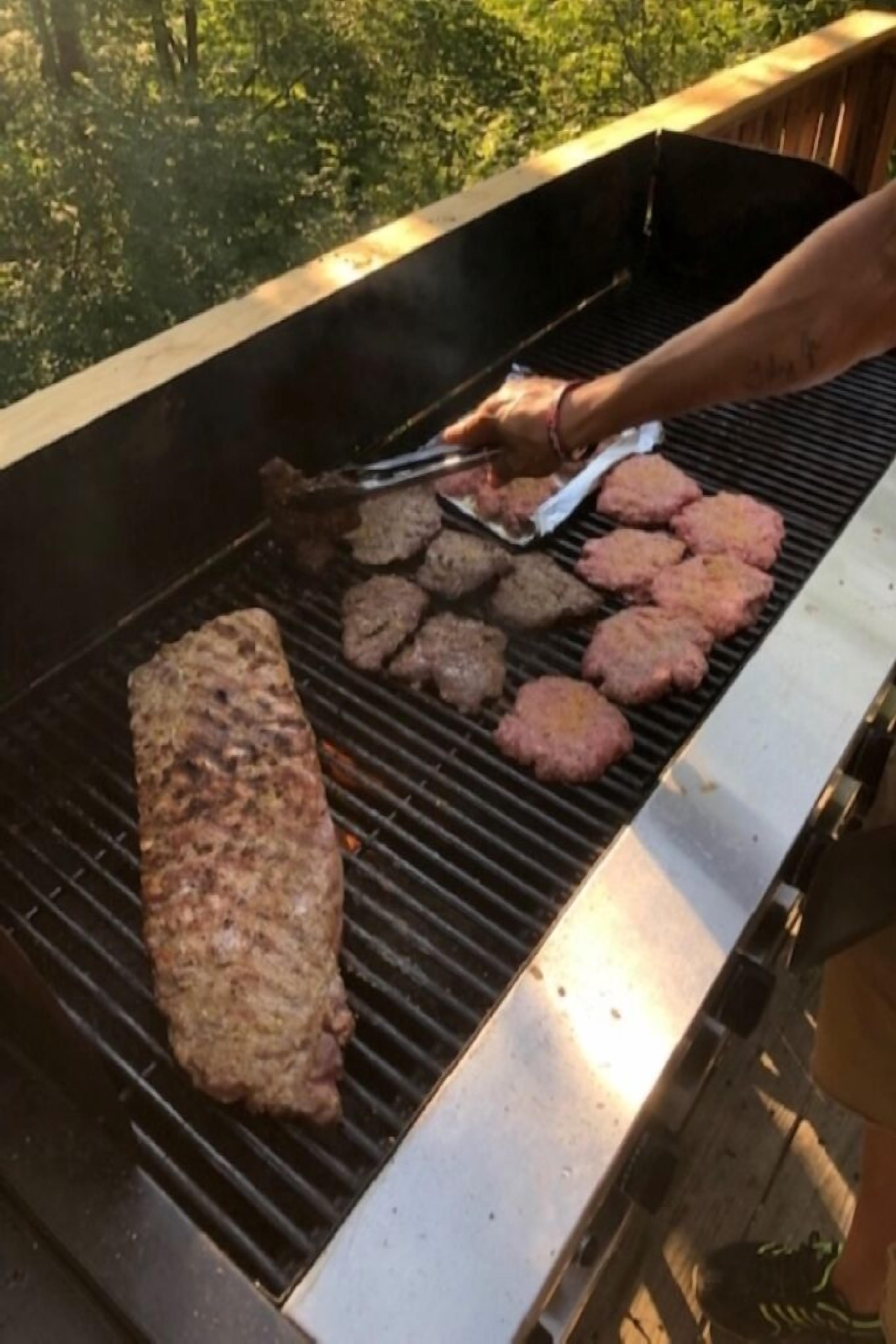 Un barbecue où de la viande est en train de cuire à l’extérieur.