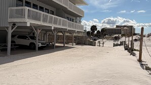 Hotel a primera línia de platja, amb una estructura de diversos pisos, zona d'estar a l'aire lliure i una àrea de sorra.