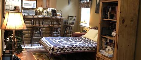 A cozy, compact living space with a kitchen, dining area, and a bed.