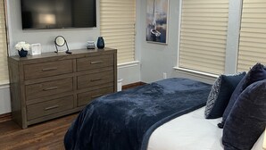 A bedroom with a bed, dresser, TV, ceiling fan, and windows. - Very Best Sunset! Deep Water! 149ft waterfront-4BR/Sleeps 14, New Remodel (Mabank)