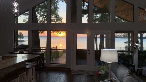 A spacious living area with large windows offering views of the sunset over a body of water. - Very Best Sunset! Deep Water! 149ft waterfront-4BR/Sleeps 14, New Remodel (Mabank)
