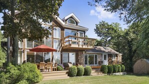 Une maison à deux étages avec un patio couvert, une grande fenêtre et un garage.