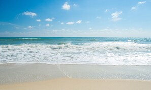A beach with waves, a clear sky, and a distant horizon. - TOTALLY BEACHIN' - BEACHES OPEN! BOOK NOW! STEPS TO SHOPS, BEACH, POOL! (Panama City Beach)