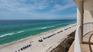 A beach view from a balcony overlooking a sandy beach with rows of umbrellas and beach chairs. - LONG BEACH RESORT Tower 2, 13th Floor 1 Bdr!!  Awesome Views! Beautiful Unit!!! ! (Panama City Beach)