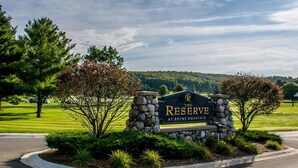 Schild für "The Reserve at Boyne Mountain" mit Steinmauer und Grünpflanzen.