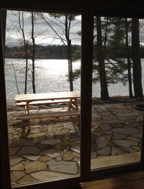 A stone patio with a wooden bench overlooking a lake. - Bass Lk~Eagle River~Level to Water~Beautiful Sand Beach Front (Eagle River)
