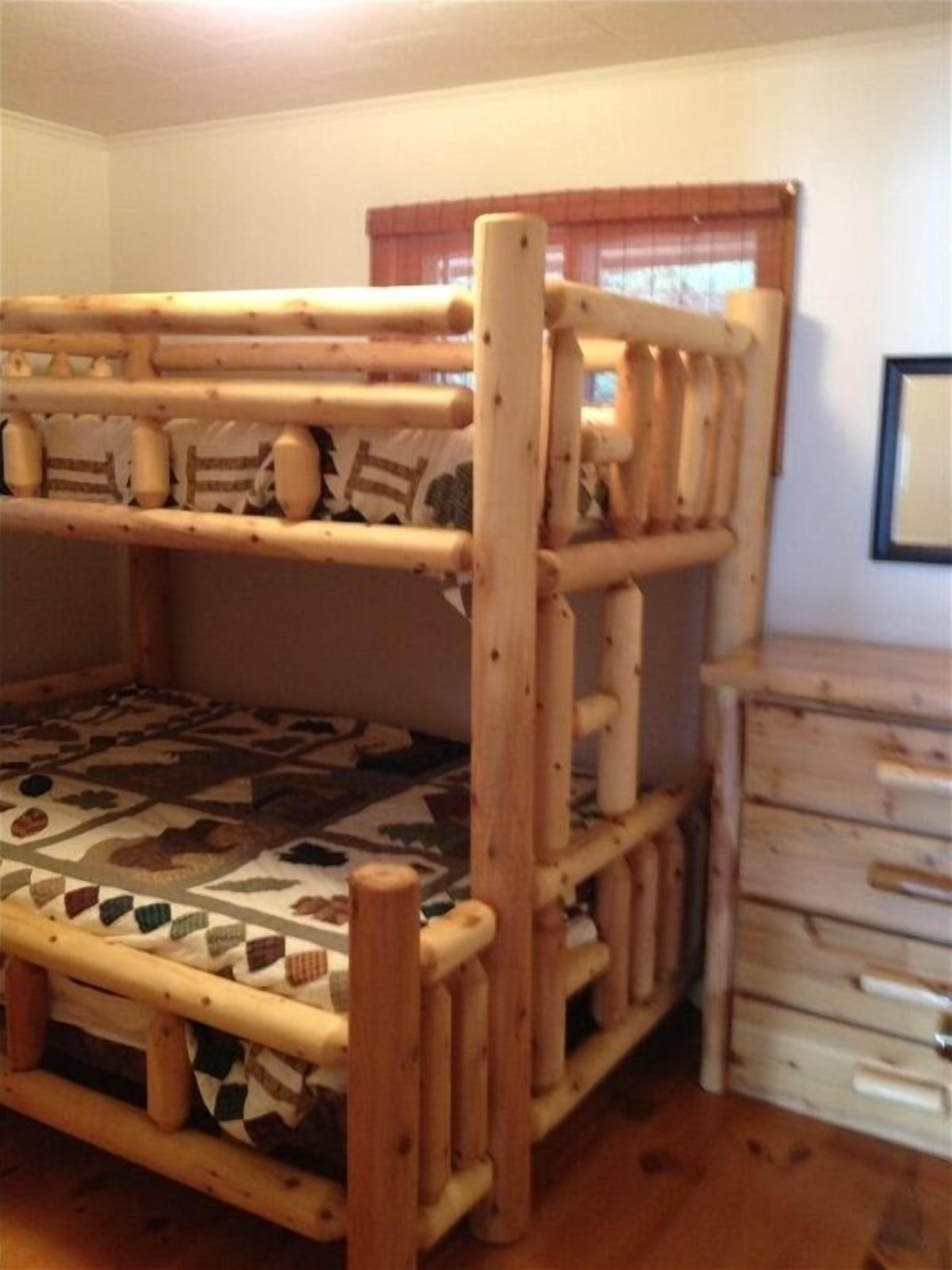 A bunk bed with a patterned mattress, wooden headboard, and a dresser with multiple drawers.