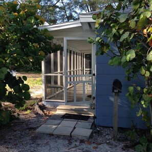 A small, single-story building with a covered porch and a mailbox.
