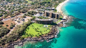 Vista aérea de un hotel frente al mar con piscina, varias edificaciones y una playa.
