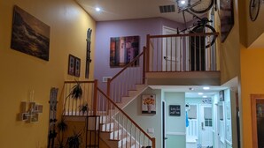 Interno di una casa su più livelli, con una scala, attrezzatura da sci e una bicicletta.