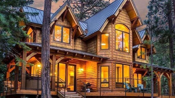 Un'ampia baita di legno con molte finestre e un portico coperto.