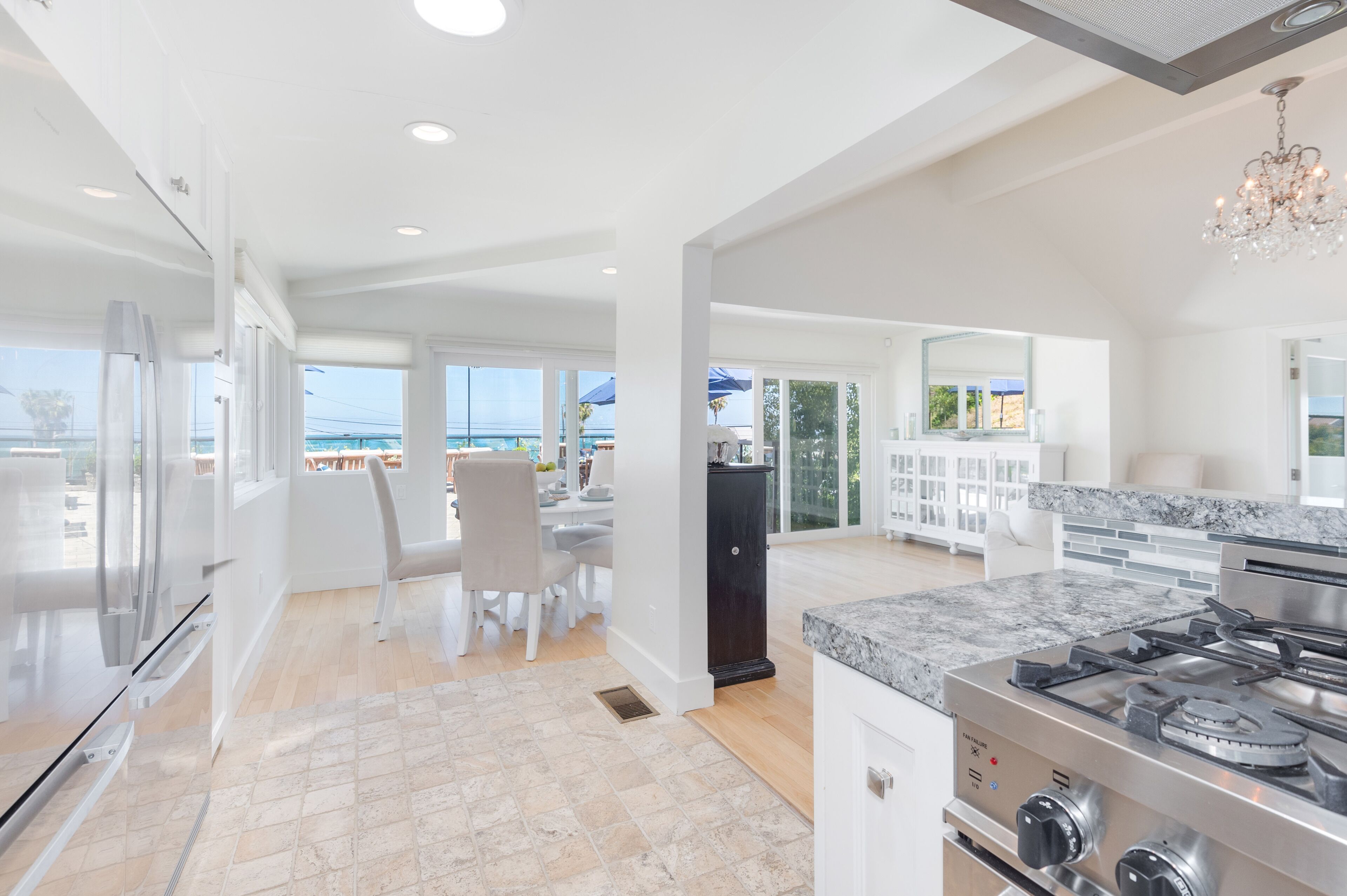 Una cocina moderna con una isla grande, electrodomésticos de acero inoxidable y vistas al exterior.