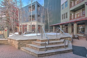 Un área de spa con jacuzzis, escalones de piedra y asientos exteriores.