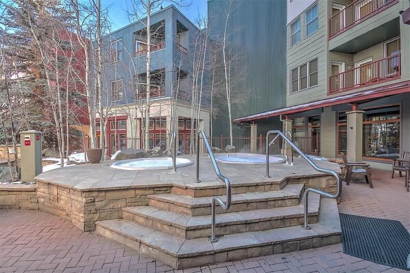 Un espace spa doté de bains à remous et d’escaliers en pierre.