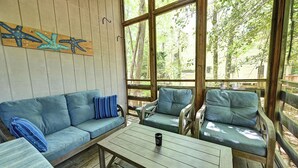 A wooden deck with a sofa, chairs, and a table. - Cozy 3 bedroom 2 bath beach house with private setting! Pool, Trolley, Wifi, Beach Town! (Bethany Beach)
