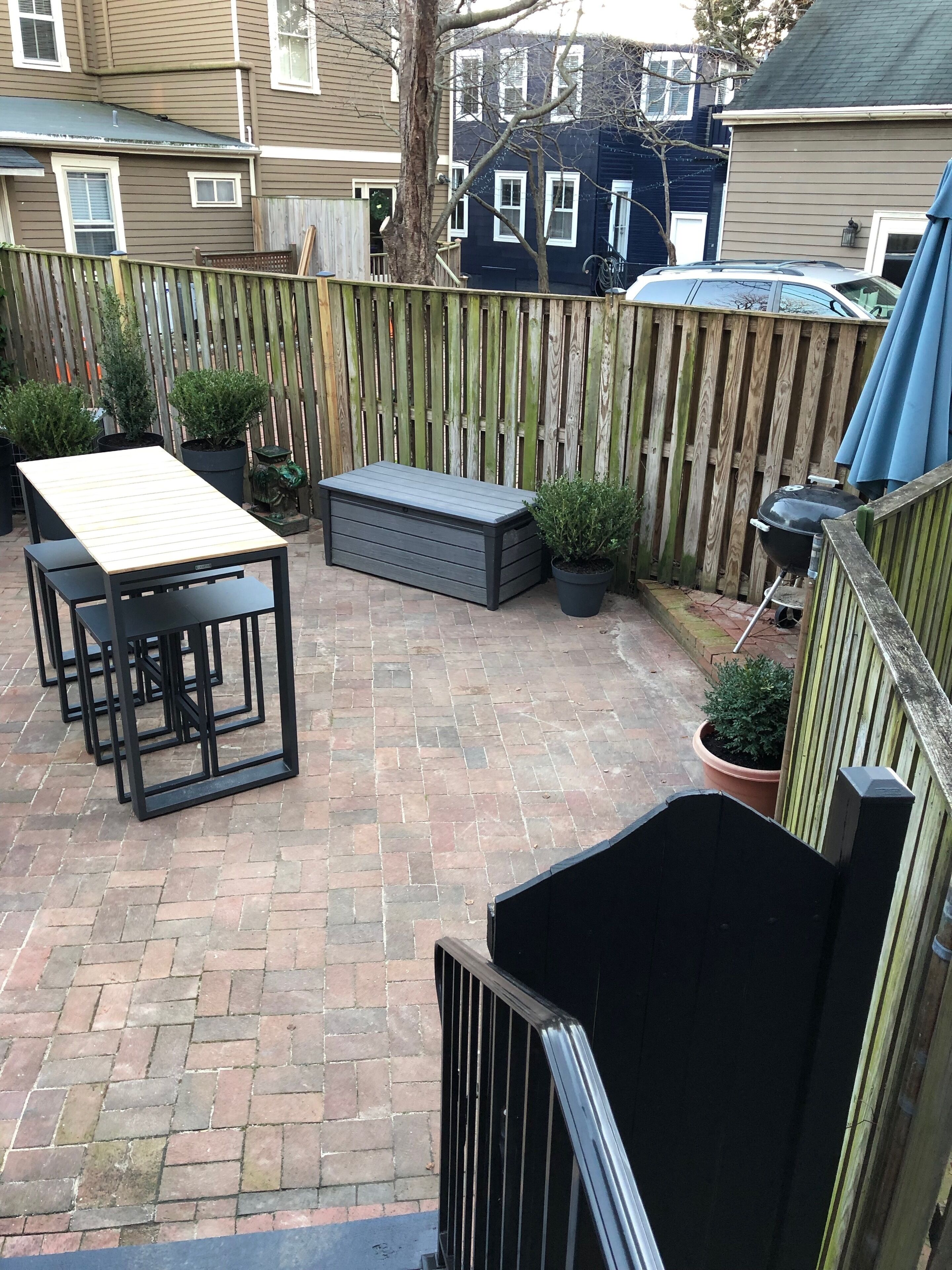 Eine Terrasse mit Tisch, Stühlen, einer Sitzbank und Kübelpflanzen.