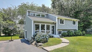 A two-story house with a front yard, a driveway, and a basketball hoop. - Fantastic Contemporary ,Min to Narr beach. (Narragansett)