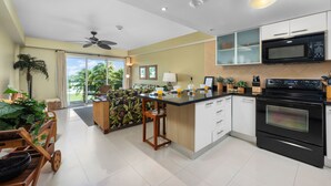 Une cuisine moderne dotée d’un îlot central, d’un four à micro-ondes et d’un four traditionnel.